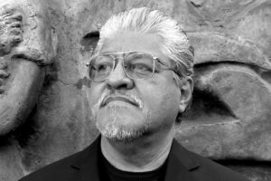 Author photo of Luis Rodriguez in front of a rock wall.