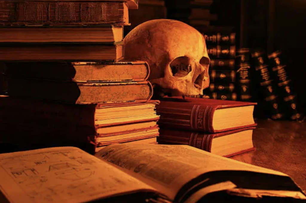 A skull on a desk next to books